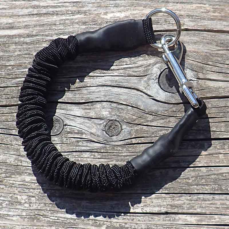 The black version of the stretchable dog leash for training with pulling dogs outdoor on wood.